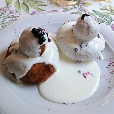 Papanasi – Rumänische Topfenknödel<br />
Ein besonderes Highlight auf unserer Speisekarte sind die Papanasi, die köstlichen rumänischen Topfenknödel. Diese himmlischen Desserts werden aus frischem Quark (Topfen), Mehl und Eiern zubereitet und anschließend zu perfekten kleinen Knödeln geformt. Die Papanasi werden goldbraun gebacken oder frittiert, was ihnen eine unwiderstehlich knusprige Außenseite und einen weichen, zarten Kern verleiht.